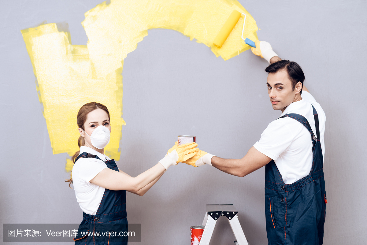 一名年轻女子和一名阿拉伯相貌的男子是一名画家。一个女人和一个男人正在刷墙。